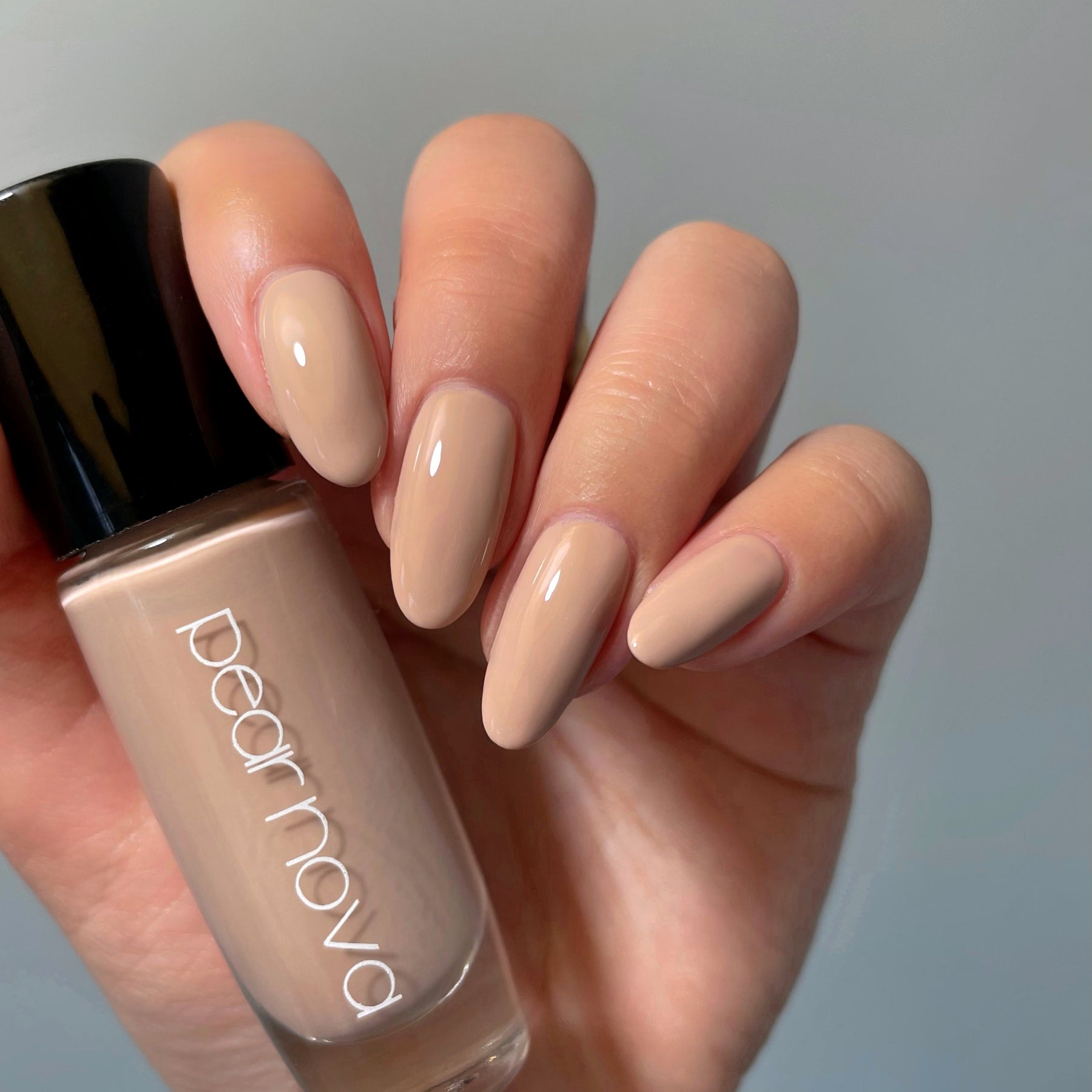 hands holding a pear nova nail polish